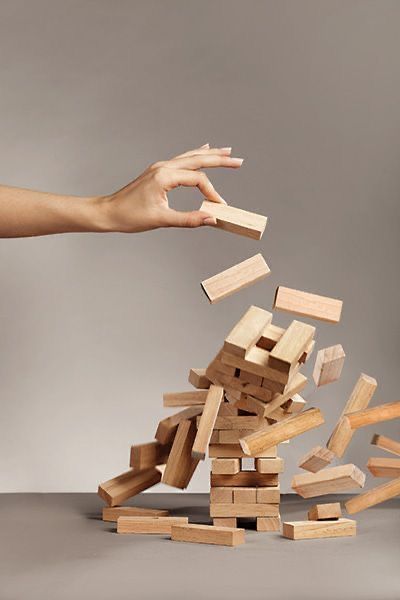 Dłoń wyciągająca klocek z wieży Jenga